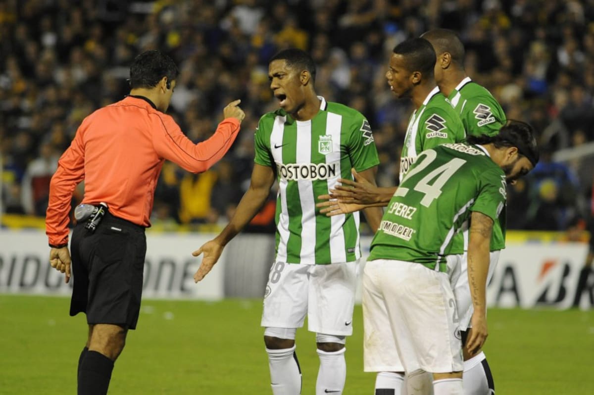 Orlando Berrio (c) de Nacional discute con el arbitro Sandro Ricci 