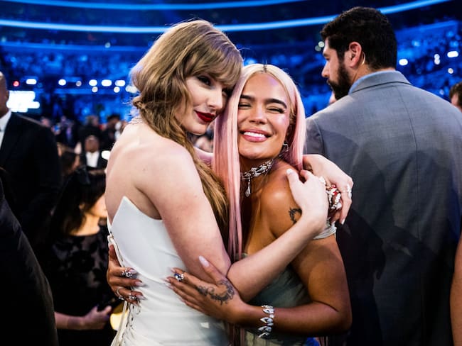 Taylor Swift (izquierda de blanco) y Karol G (derecha de gris) en los Premios Grammy edición 66. Foto: Getty Images.
