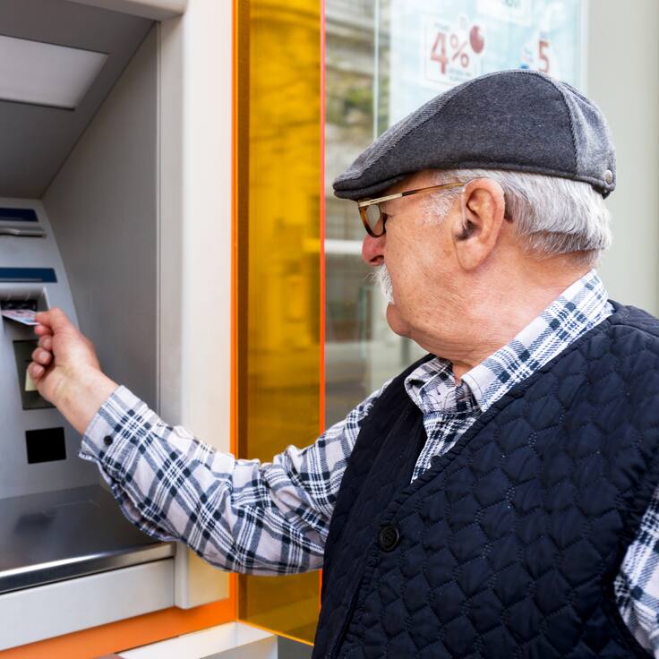 Hombre mayor retirando dinero del cajero (Getty Images)