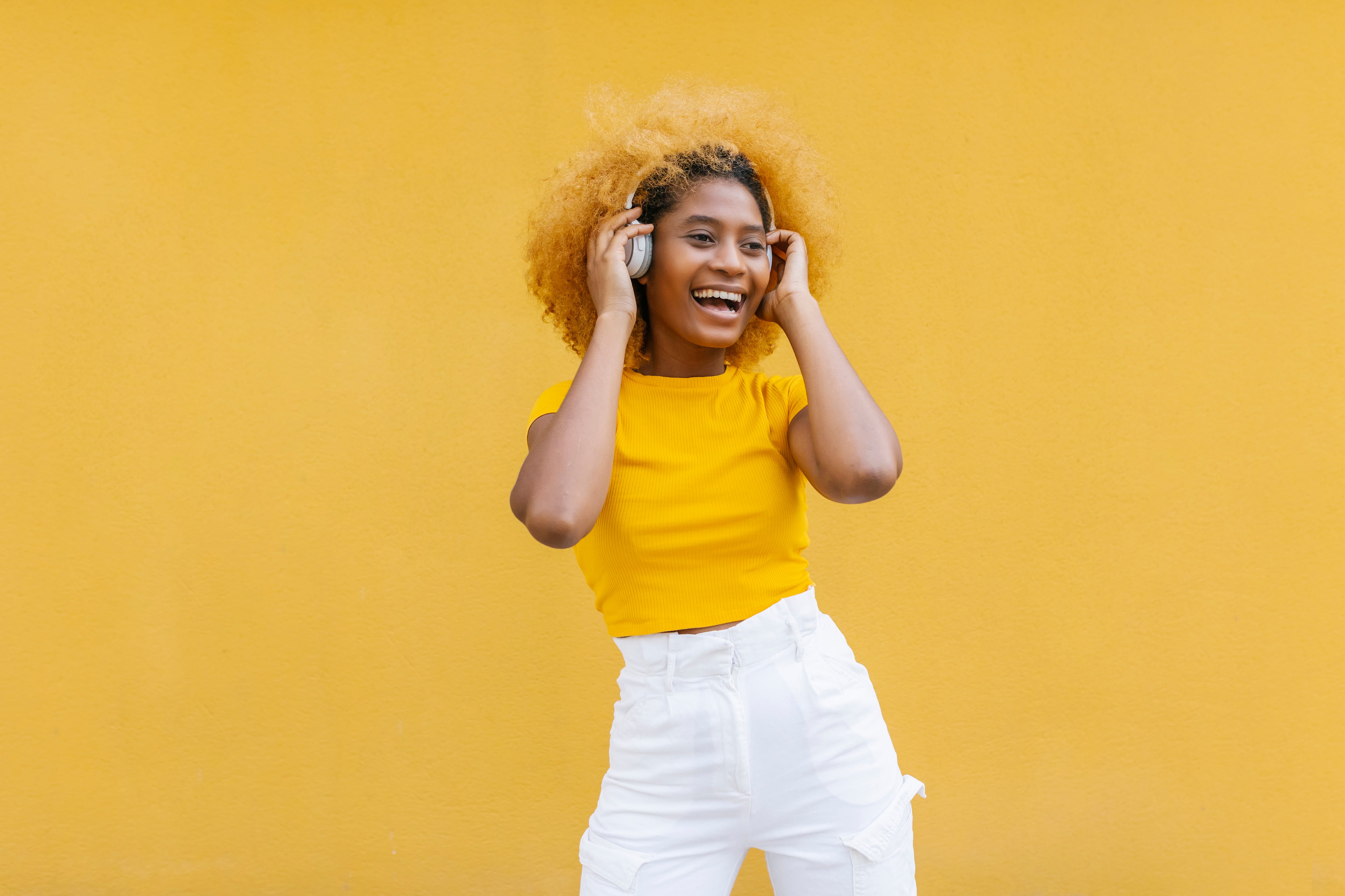 Mujer alegre vestida de amarillo/ Getty Images