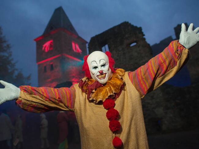 Un visitante disfrazado de payaso &quot;Pennywise&quot; de &quot;It&quot; de Steven King se encuentra frente al castillo de Frankenstein en el espectáculo de Halloween en Muehltal, Alemania, el 22 de octubre de 2016.