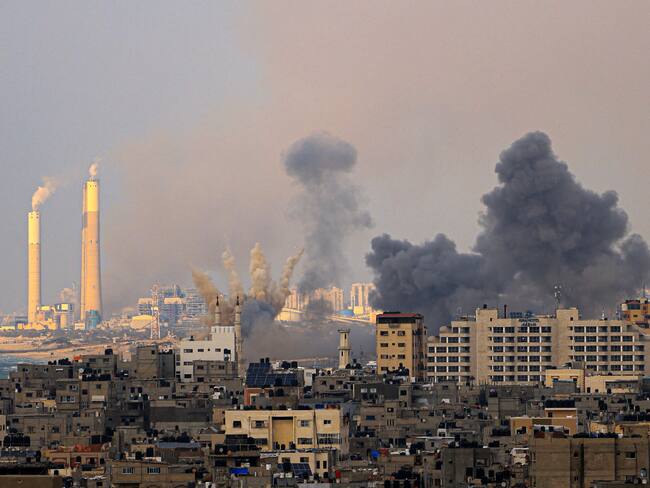 Smoke billows behind highrise buildings in Gaza City during Israeli air strikes on October 9, 2023, with the Rutenberg power station, north of the border Israeli kibbutz of Zikim, seen in the background. (Photo by MAHMUD HAMS / AFP) (Photo by MAHMUD HAMS/AFP via Getty Images)