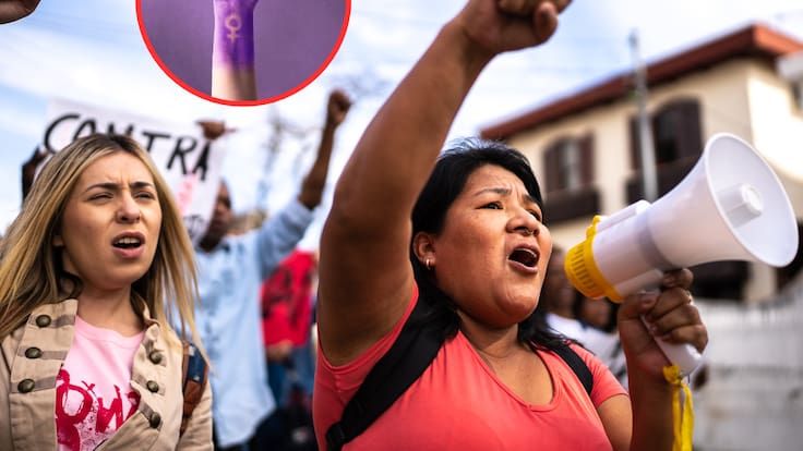 Mujeres durante una manifestación, de fondo el símbolo de lucha femenina (Fotos vía Getty Images)