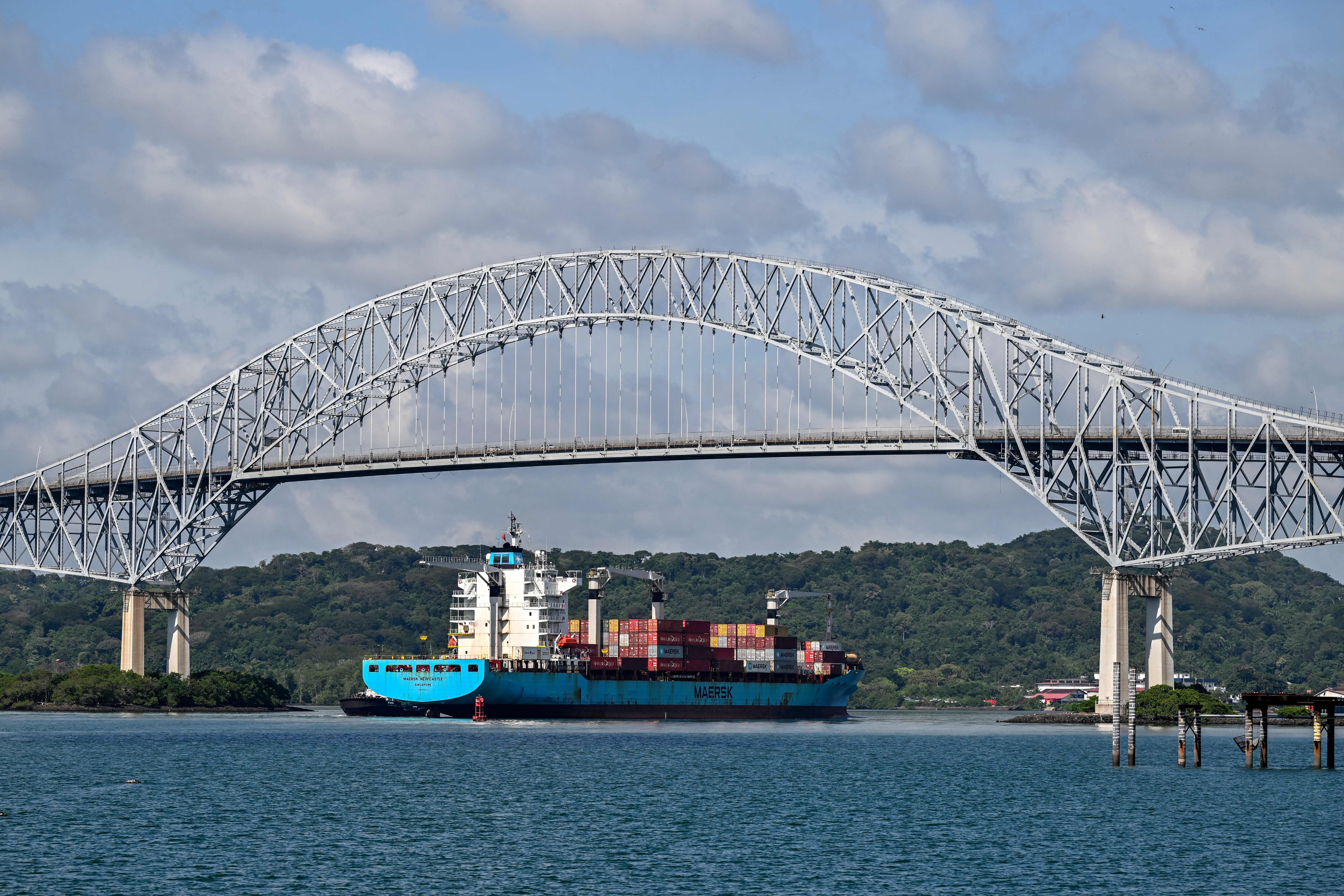 A ship navigateS the Panama canal in the area of Americas' Bridge in Panama City on December 16, 2022. - Every time a ship crosses the Miraflores Lock, the Panama Canal's most famous gate, 200 million liters of fresh water are discharged into the sea. This operation was repeated more than 14,000 times during 2022 in this strategic passageway linking the world's two largest oceans, whose main source of energy to move ships is rainwater. (Photo by Luis ACOSTA / AFP) (Photo by LUIS ACOSTA/AFP via Getty Images)