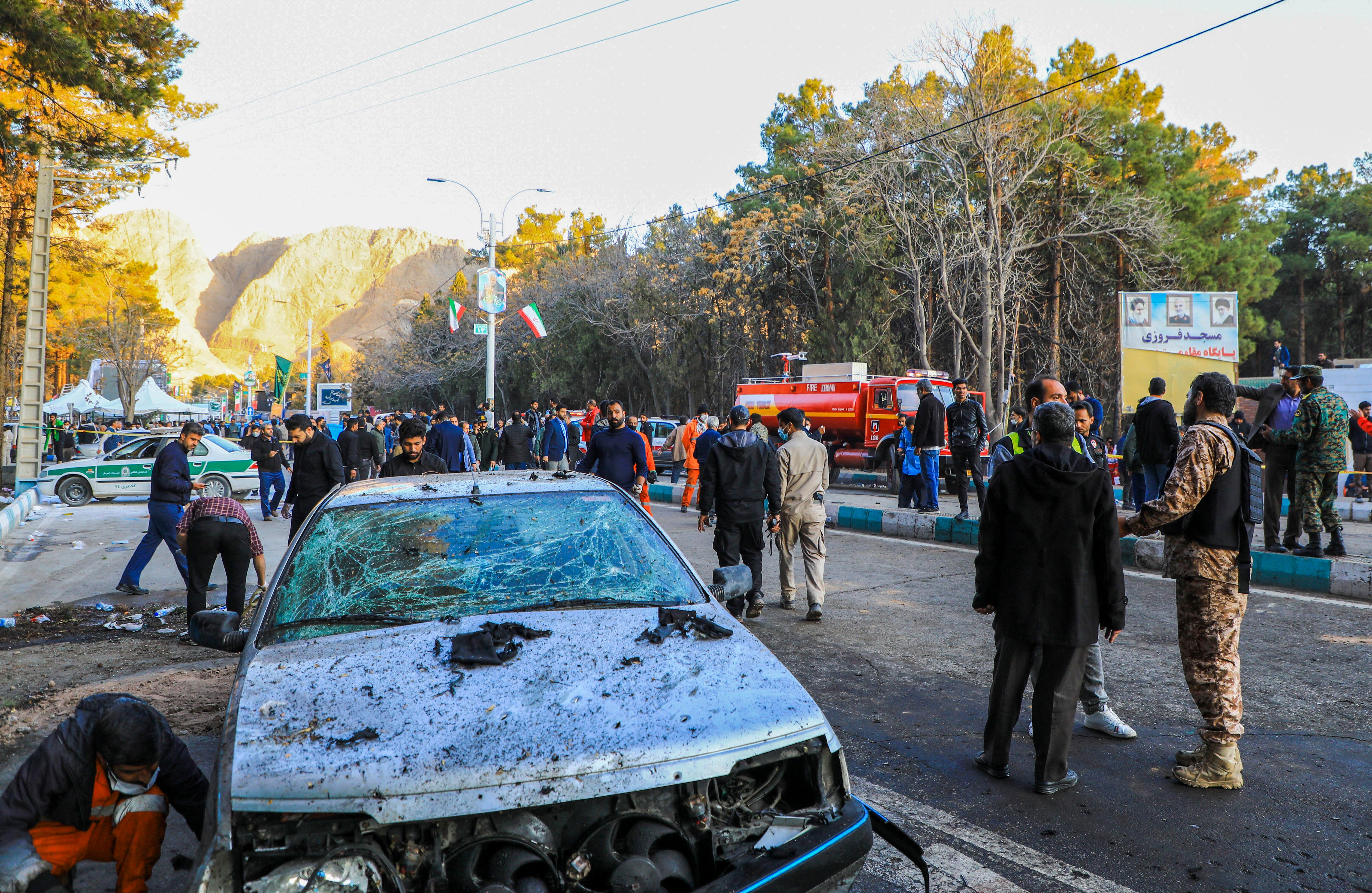 TOPSHOT - This picture shows people and Iranian emergency personnel at the site where two explosions in quick succession struck a crowd marking the anniversary of the 2020 killing of Guards general Qasem Soleimani, near the Saheb al-Zaman Mosque in the southern Iranian city of Kerman on January 3, 2024. Iran's president Ebrahim Raisi condemned on January 3 twin blasts that killed at least 103 people in the country's south where crowds gathered to mark the killing of general Qasem Soleimani. (Photo by Sare Tajalli / ISNA / AFP) (Photo by SARE TAJALLI/ISNA/AFP via Getty Images)