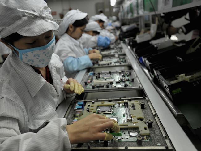 Ensamble de componentes electrónicos en centro de trabajo chino.
(Foto:   AFP/AFP via Getty Images)