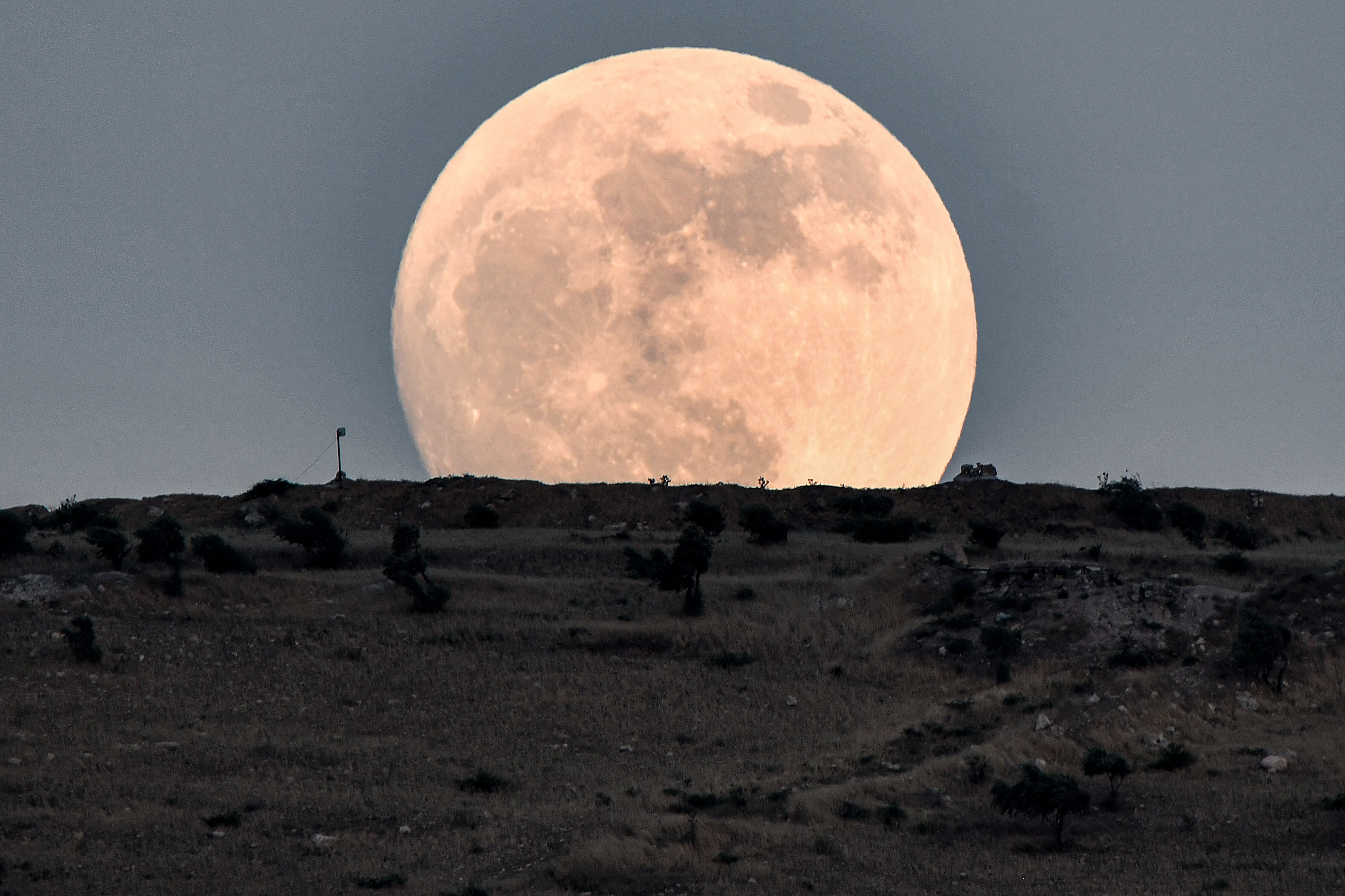 Vista de la superluna de fresa desde Siria. (Photo by Rami al SAYED / AFP)