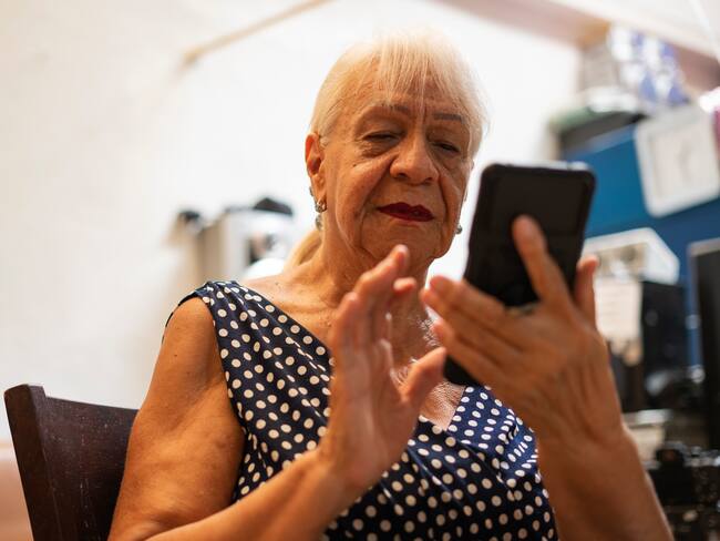 Mujer mayor revisando su celular en Bogotá (Getty Images)