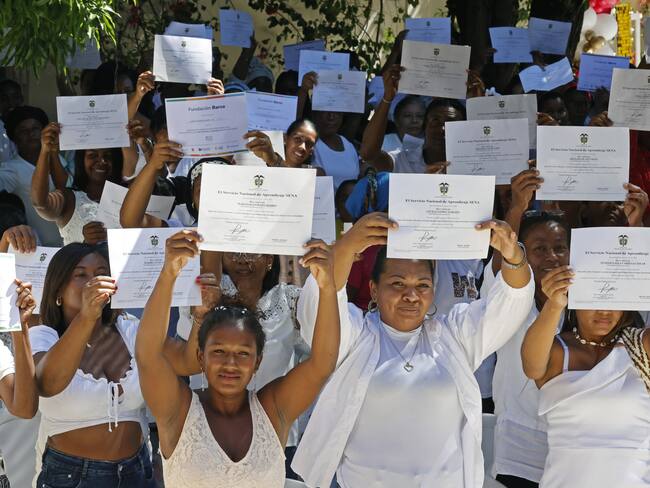 AME3249. SAN JUAN NEPOMUCENO (COLOMBIA), 09/12/2023.- Mujeres cuidadoras alzan los certificados que acaban de recibir luego de cursar el "Taller de apropiación cultural, proyecto piloto Rutas del Cuidado Montes de María" hoy, en San Juan Nepomuceno, departamento de Bolívar (Colombia). Es apenas una cartulina blanca con el logo del Gobierno colombiano, pero que le certifica en cuidados, en reconocimiento de una labor imprescindible en cualquier país pero también invisibilizada, especialmente en zonas rurales como esta. EFE/Mauricio Dueñas Castañeda