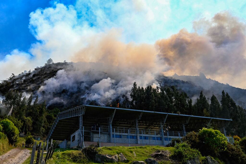El humo surge de un incendio forestal cerca de un coliseo deportivo en Nemocón, Colombia, el 24 de enero de 2024.  (Foto de Luis ACOSTA/AFP) (Foto de LUIS ACOSTA/AFP vía Getty Images)