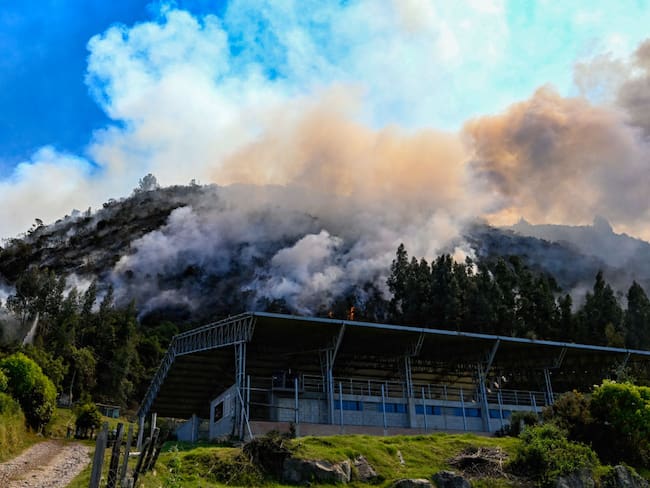 El humo surge de un incendio forestal cerca de un coliseo deportivo en Nemocón, Colombia, el 24 de enero de 2024.  (Foto de Luis ACOSTA/AFP) (Foto de LUIS ACOSTA/AFP vía Getty Images)
