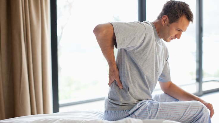 Hombre despertando con dolor de espalda (Foto vía Getty Images)