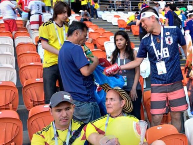 Japoneses y colombianos recogen la basura del estadio. 