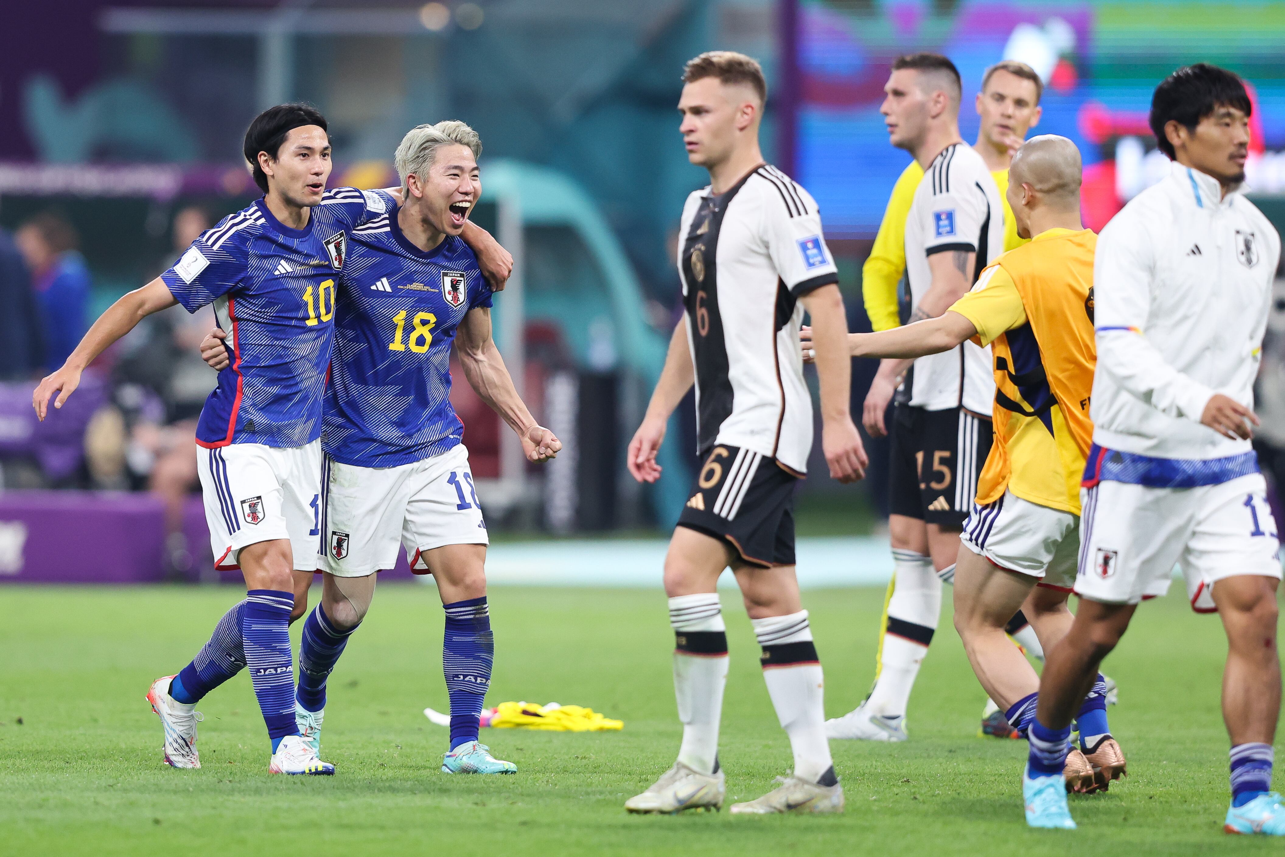 DOHA, QATAR - NOVEMBER 23: Takuma Asano and Takumi Minamino of Japan celebrate on the final whistle during the FIFA World Cup Qatar 2022 Group E match between Germany and Japan at Khalifa International Stadium on November 23, 2022 in Doha, Qatar. (Photo by Alex Livesey - Danehouse/Getty Images)