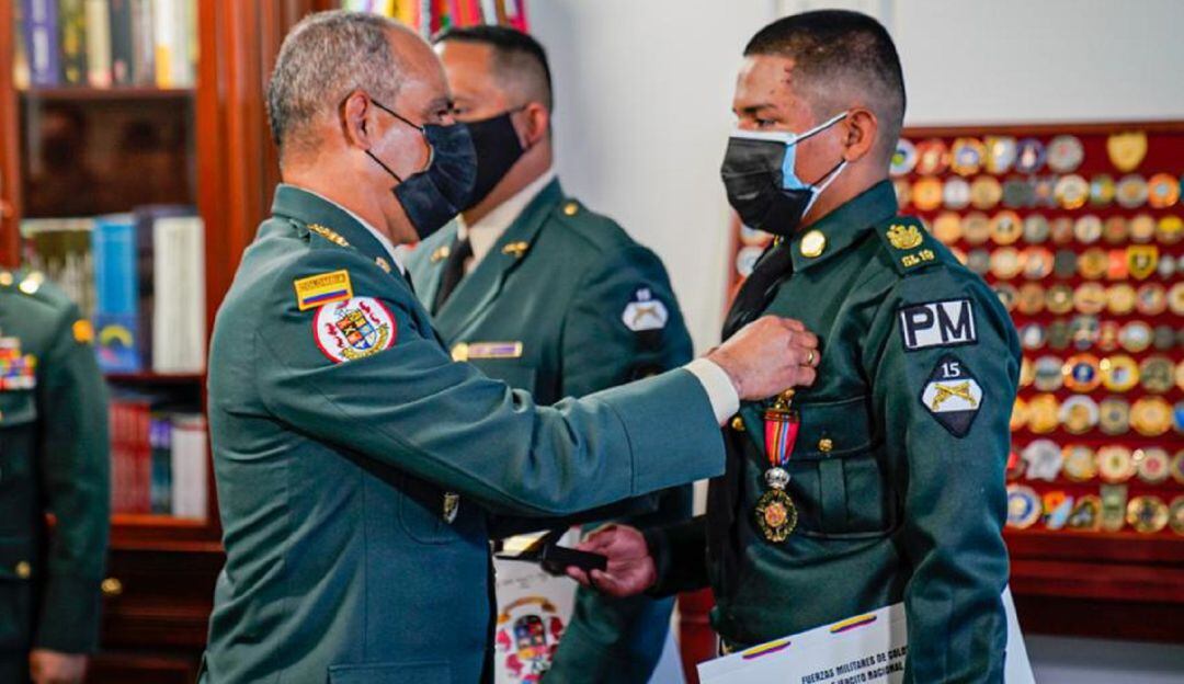 Comandante del Ejército (Izquierda) condecora a soldado que lleva seis meses de servicio militar.