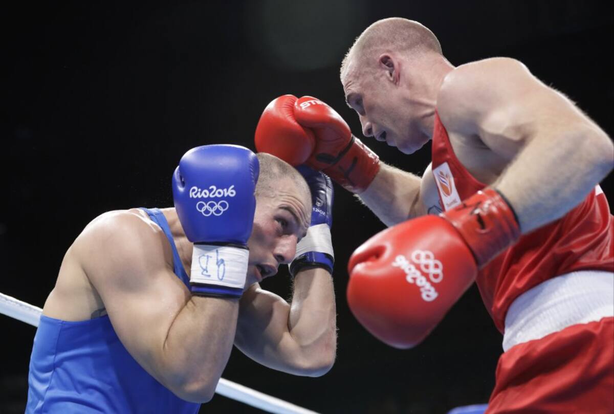 El holandés Peter Mullenberg (derecha) compite con el iraní Ehsan Rouzbahani durante la pelea de boxeo preliminar en la categoría peso pesado de 81 kg masculino.