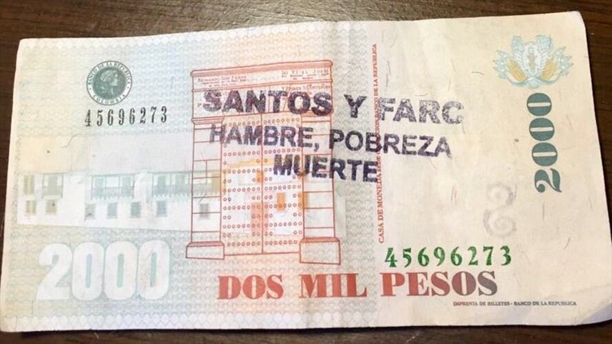 Billete de $2000 con un sello en el que se lee "Santos y Farc. Hambre, pobreza, muerte". Foto: En Twitter, @rafacolontorres