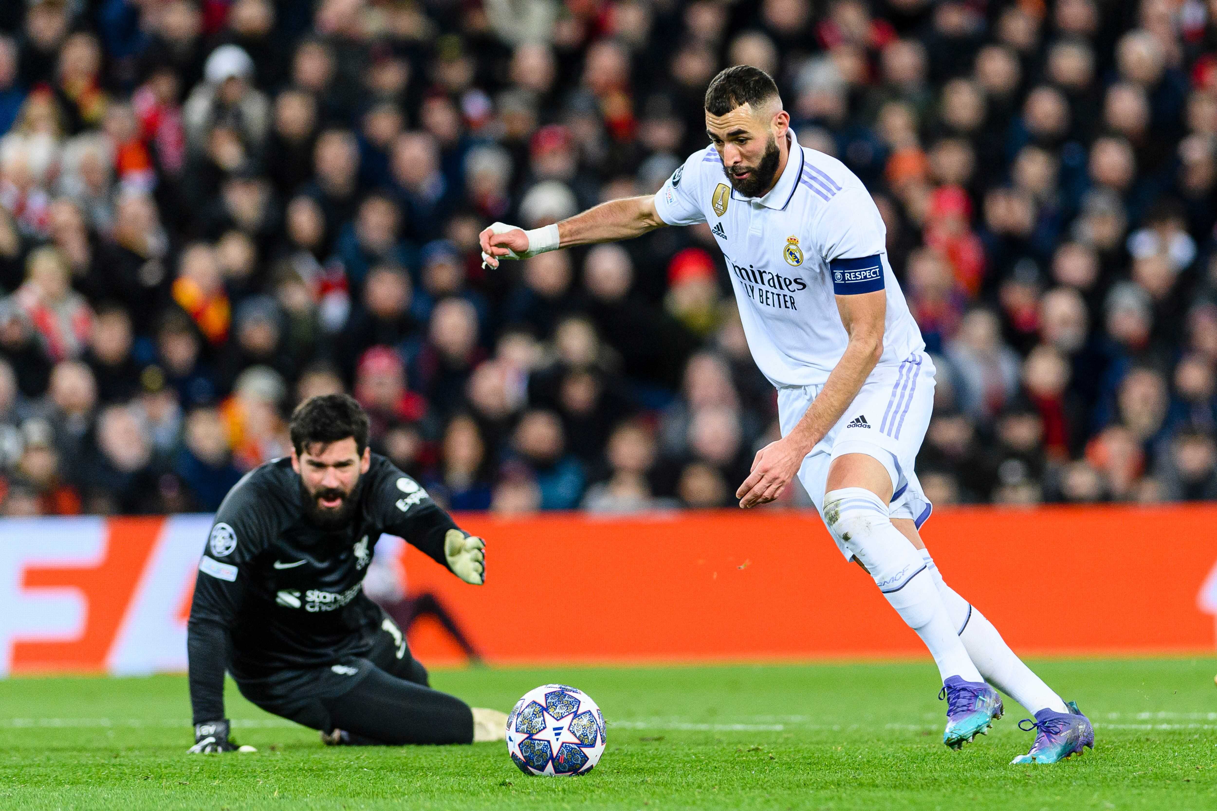 LIVERPOOL, ENGLAND - FEBRUARY 21: Karim Benzema of Real Madrid (R) scores his goal over Goalkeeper Alisson Becker of Liverpool (L) during the UEFA Champions League round of 16 leg one match between Liverpool FC and Real Madrid at Anfield on February 21, 2023 in Liverpool, United Kingdom. (Photo by Richard Callis/Eurasia Sport Images/Getty Images)