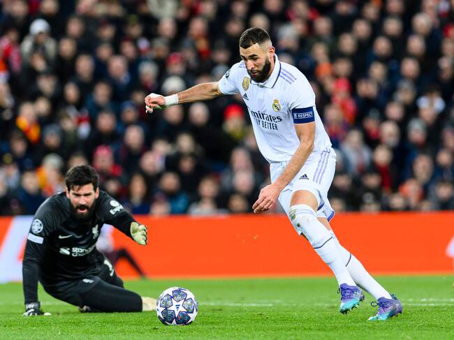 LIVERPOOL, ENGLAND - FEBRUARY 21: Karim Benzema of Real Madrid (R) scores his goal over Goalkeeper Alisson Becker of Liverpool (L) during the UEFA Champions League round of 16 leg one match between Liverpool FC and Real Madrid at Anfield on February 21, 2023 in Liverpool, United Kingdom. (Photo by Richard Callis/Eurasia Sport Images/Getty Images)