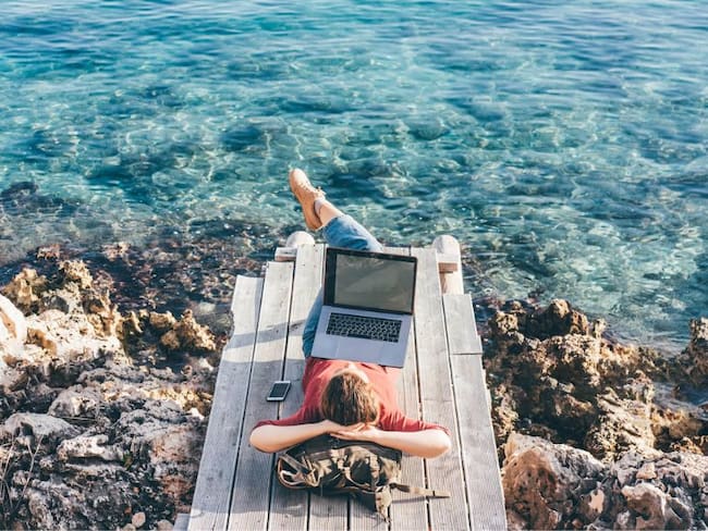 Mujer trabajando en la playa/ Getty Images