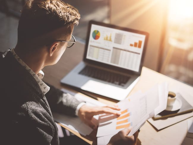 Hombre analizando grráficas y datos financieros (Fotos vía Getty Images)