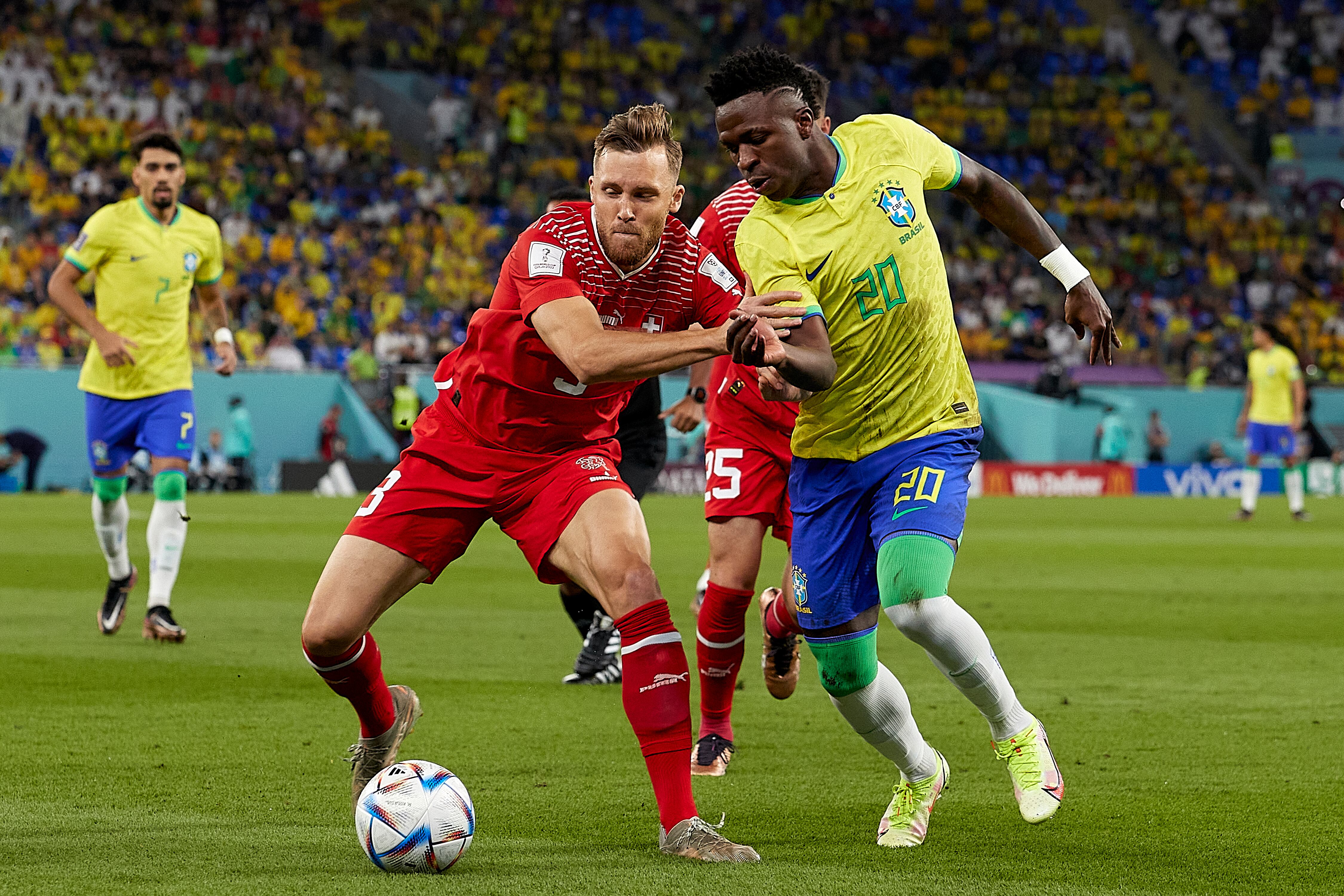 DOHA, QATAR - NOVEMBER 28 Silvan Widmer of Switzerland competes for the ball with Vinicius Junior of Brazil during the FIFA World Cup Qatar 2022 Group G match between Brazil and Switzerland at Stadium 974 on November 28, 2022 in Doha, Qatar. (Photo by Juan Luis Diaz/Quality Sport Images/Getty Images)