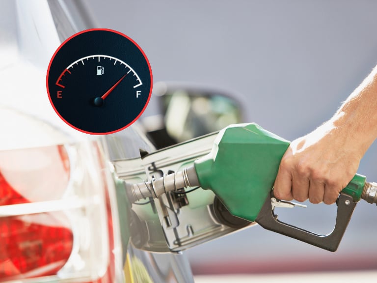 Persona suministrando gasolina a un carro y de fondo el tablero de combustible (Fotos vía Getty Images)