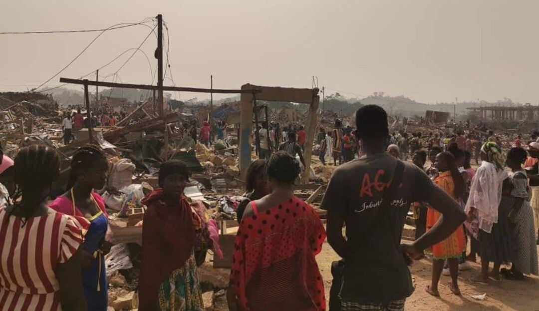 Ciudadanos ghaneses en medio de la zona donde explotó un camión que transportaba explosivos.
