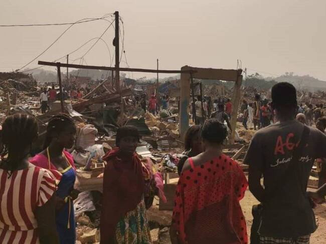 Ciudadanos ghaneses en medio de la zona donde explotó un camión que transportaba explosivos.