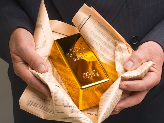 Persona sosteniendo un lingote de oro (Foto vía Getty Images)