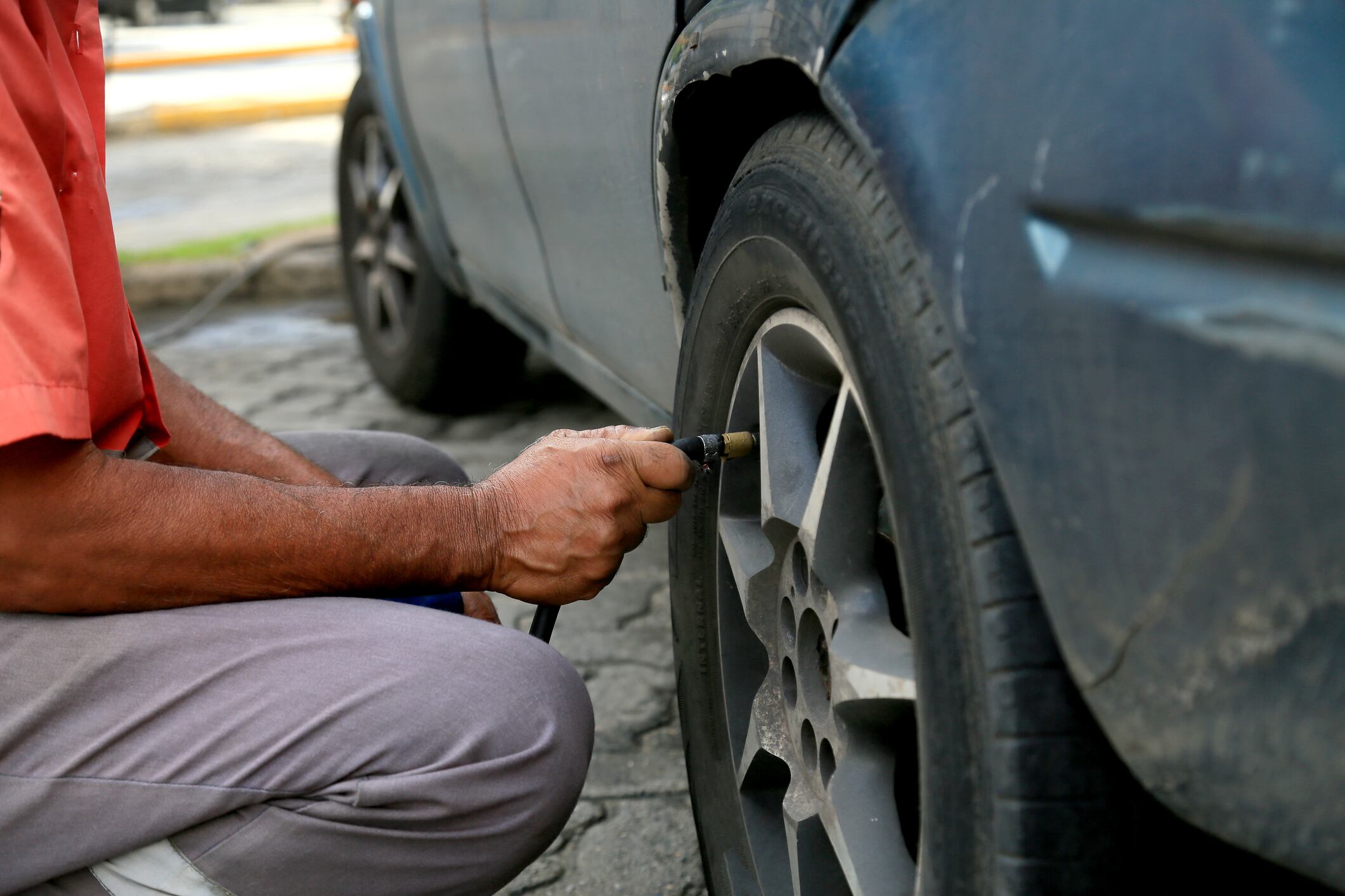 Hombre calibrando la presión de las llantas de su carro (Getty Images)
