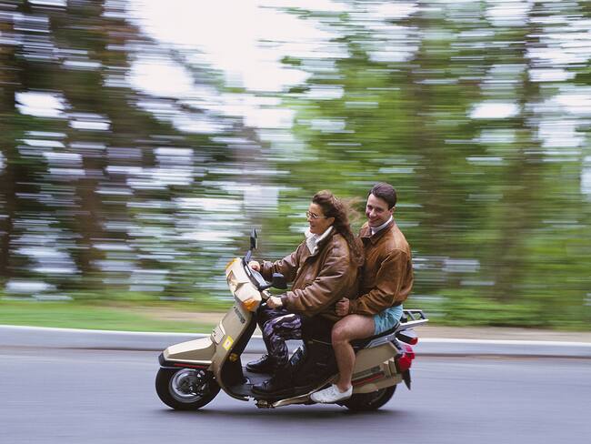 Dos personas montando moto en carretera (Getty Images)