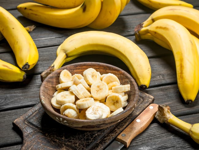 Bananos enteros y picados en un plato (Getty Images)