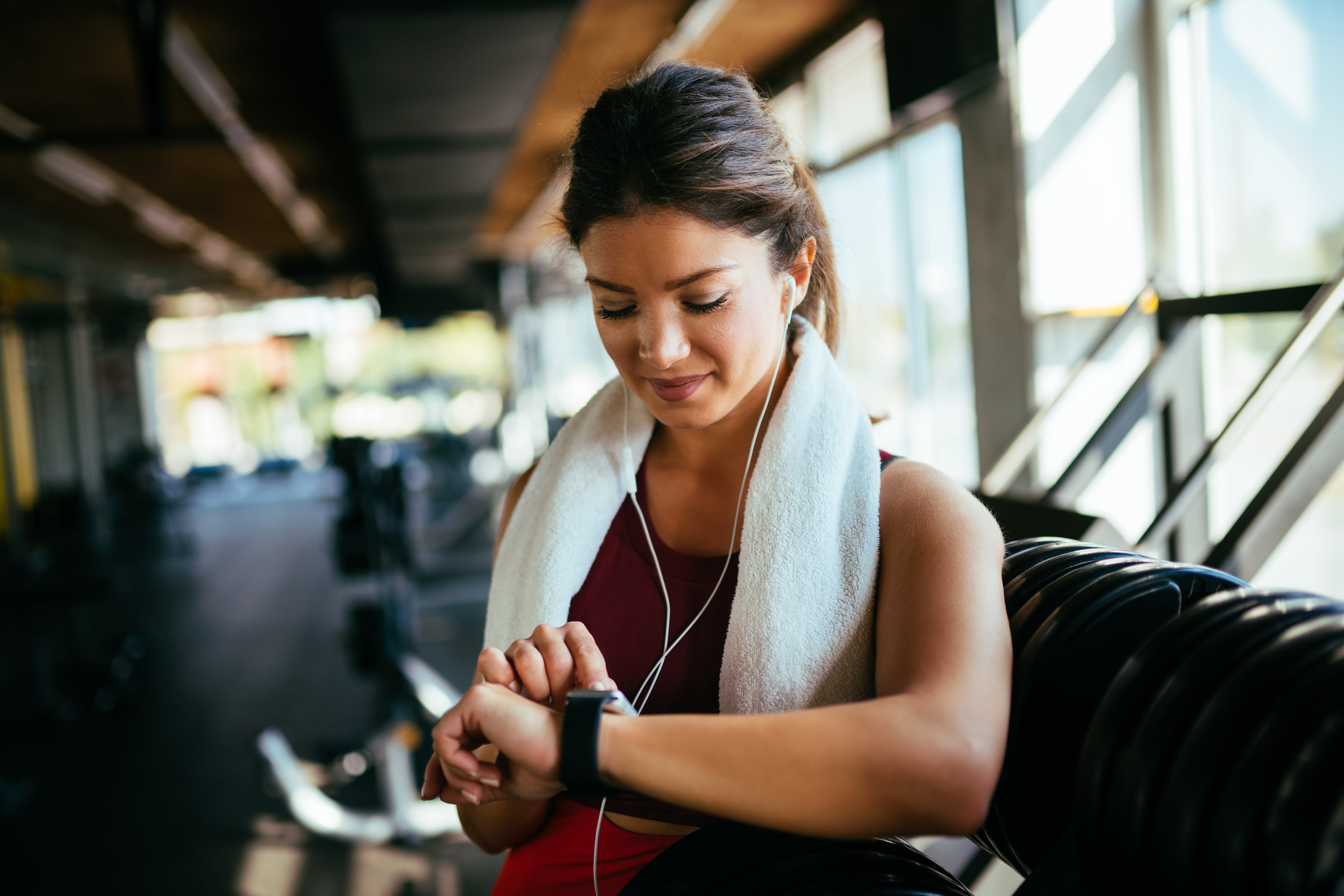 Mujer mirando la hora y haciendo ejercicio físico (Fotos vía Getty images)