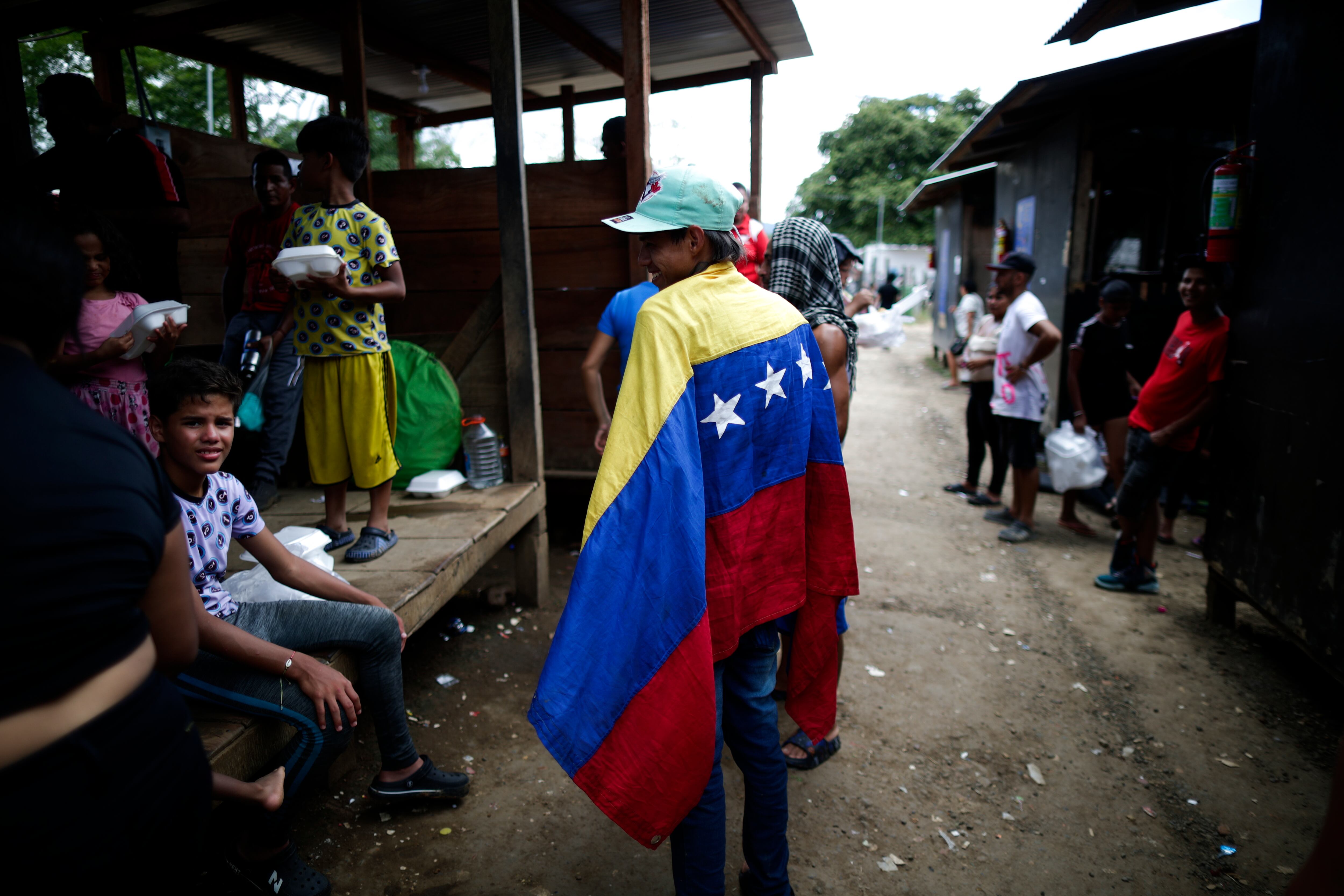 PA5001. METETÍ, PANAMÁ. 6/10/2023. William Maldonado, un migrante venezolano de 22 años sostiene una bandera de Venezuela en una estación de recepción migratoria hoy en Lajas Blancas, Metetí, Darién (Panamá).Los presidentes de Panamá, Laurentino Cortizo, y Costa Rica, Rodrigo Chaves, se desplazaron este viernes hasta la región de Darién, fronteriza con Colombia, para abordar juntos la crisis migratoria, con la llegada diaria de miles de migrantes en su camino hacia Estados Unidos. EFE/ Bienvenido Velasco