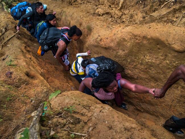 Migrantes intentando cruzar la selva del Darién, por un tramo muy angosto (Getty Images)