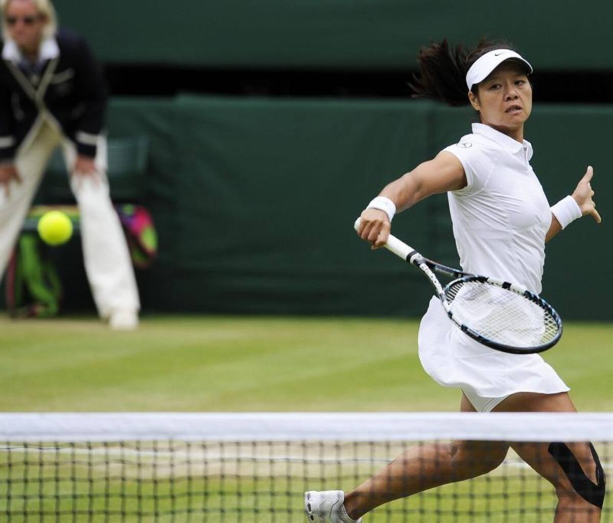 La tenista china Na Li devuelve una bola a la polaca Agnieszka Radwanska, durante el partido de cuartos de final del torneo de tenis de Wimbledon.