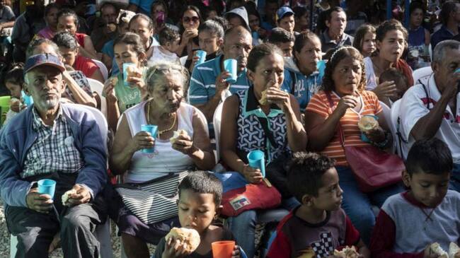 Personas refugiadas y migrantes venezolanas reciben pan en la Casa de Paso Divina Providencia, un centro de alimentación administrado por la Iglesia Católica y apoyado por ACNUR en Cúcuta, Colombia.