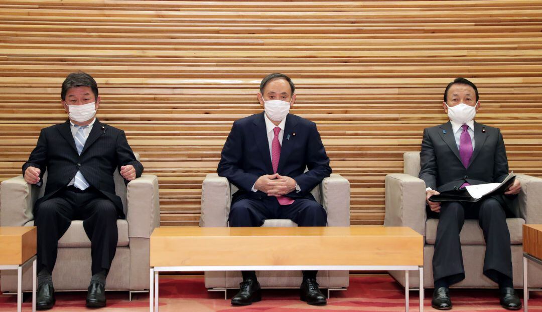 El primer ministro de Japón, Yoshihide Suga, el ministro de Relaciones Exteriores  y el ministro de Finanzas,, asisten a una reunión del gabinete en Tokio el 22 de enero de 2021, ya que el primer ministro dijo que estaba "decidido" a celebrar el Tokio. Juegos Olímpicos después de un informe nocturno que afirma que los funcionarios creen que la cancelación es inevitable.