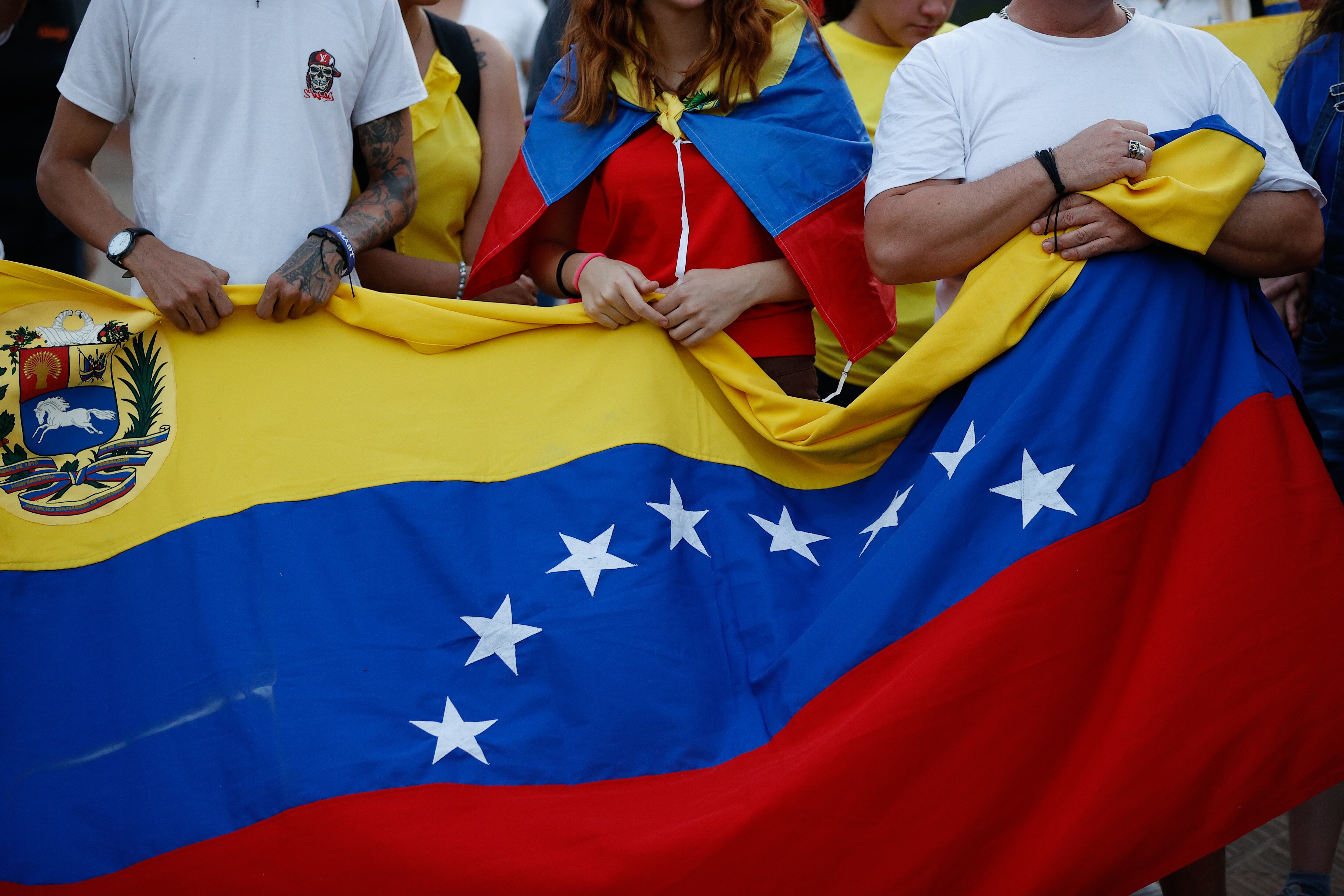AME000. ASUNCIÓN (PARAGUAY), 09/01/2025.- Venezolanos sostienen una bandera en una manifestación este jueves, en la Plaza de la Democracia en Asunción (Paraguay). El Gobierno de Paraguay expresó su condena y repudio al "secuestro" y posterior liberación de la líder opositora María Corina Machado tras concluir una concentración en Caracas, que consideró "un nuevo atentado en contra de la libertad de expresión". EFE/ Juan Pablo Pino