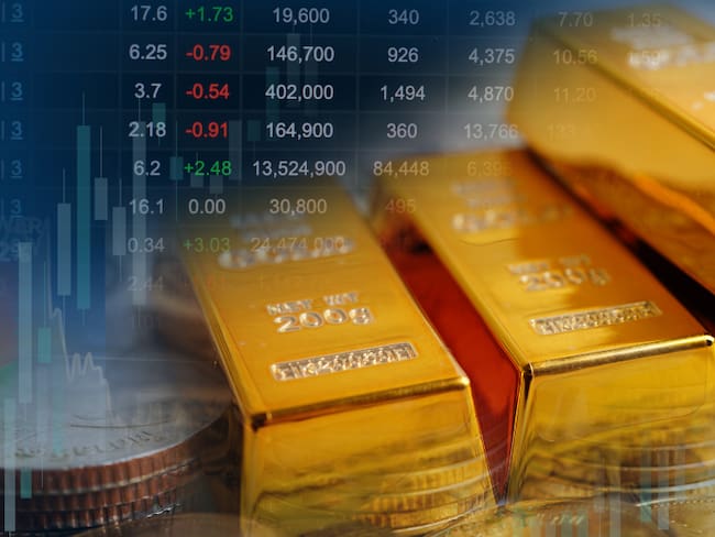 Lingote de oro, monedas e ilustración de valores cambiantes (Foto vía Getty Images)