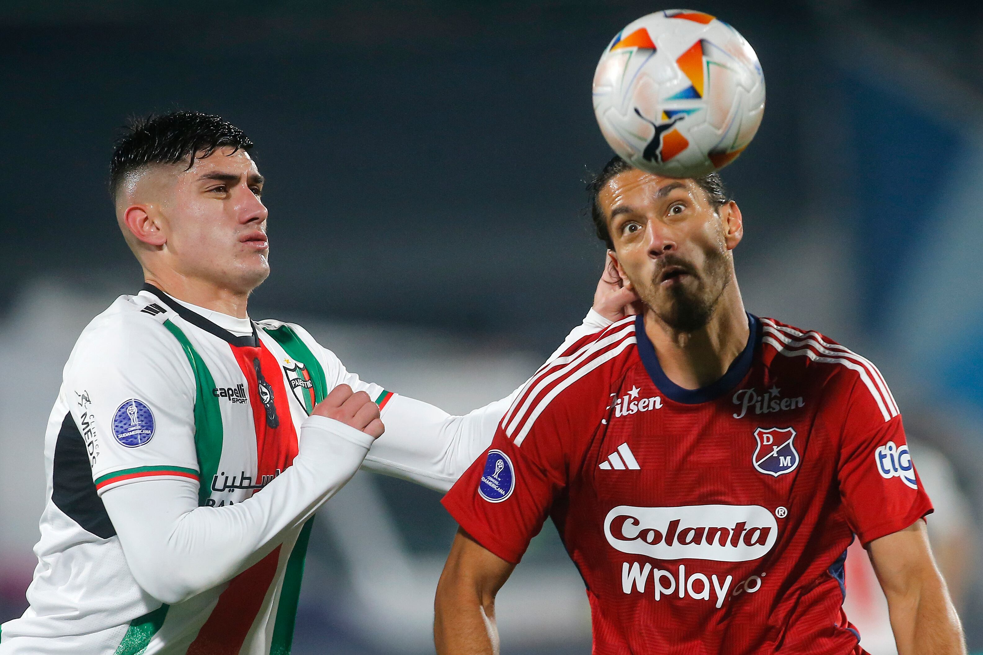 Benjamín Rojas (i) de Palestino disputa el balón con Joaquín Varela (d) de Medellín este miércoles, en el partido de ida de octavos de final de la Copa Sudamericana entre Palestino e Independiente Medellín (DIM) en el estadio Nacional Julio Martínez Prádanos en Santiago (Chile). EFE/ Esteban Garay