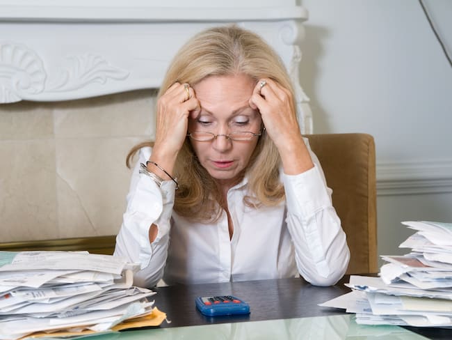 Mujer preocupada por sus cuentas y deudas financieras (Foto vía Getty Images)
