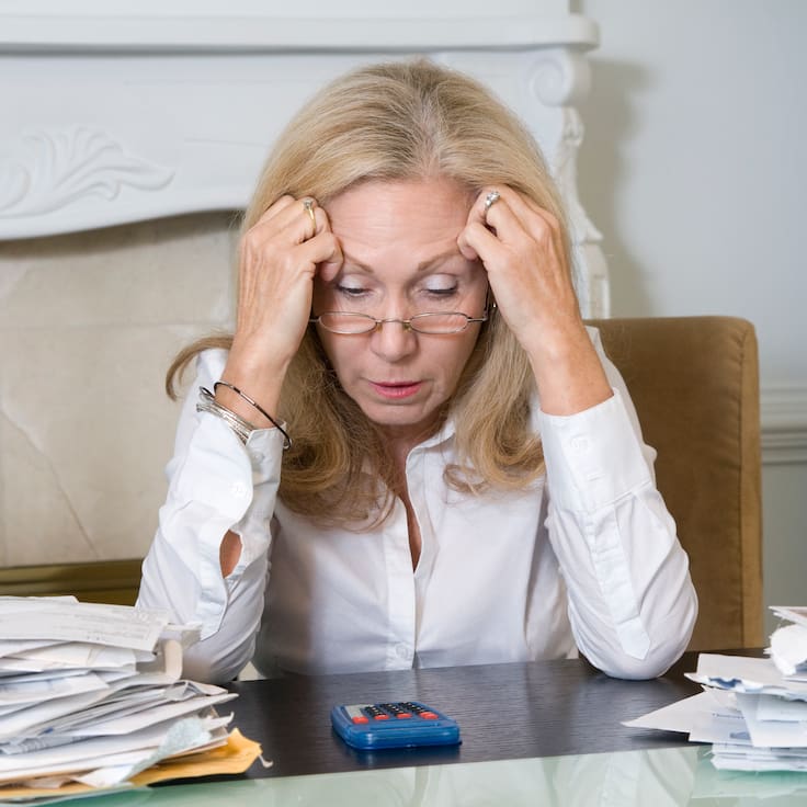 Mujer preocupada por sus cuentas y deudas financieras (Foto vía Getty Images)