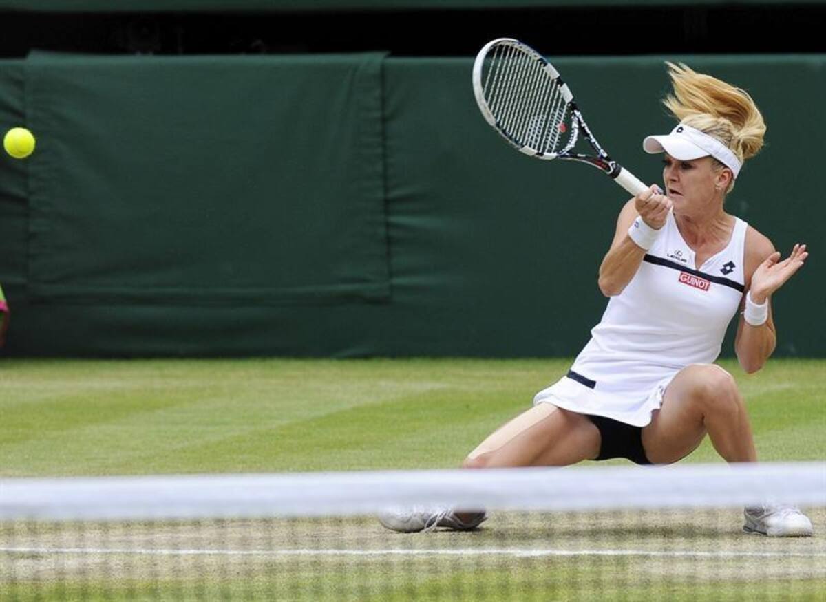 La tenista polaca Agnieszka Radwanska devuelve una bola a la china Na Li, durante el partido de cuartos de final del torneo de tenis de Wimbledon.