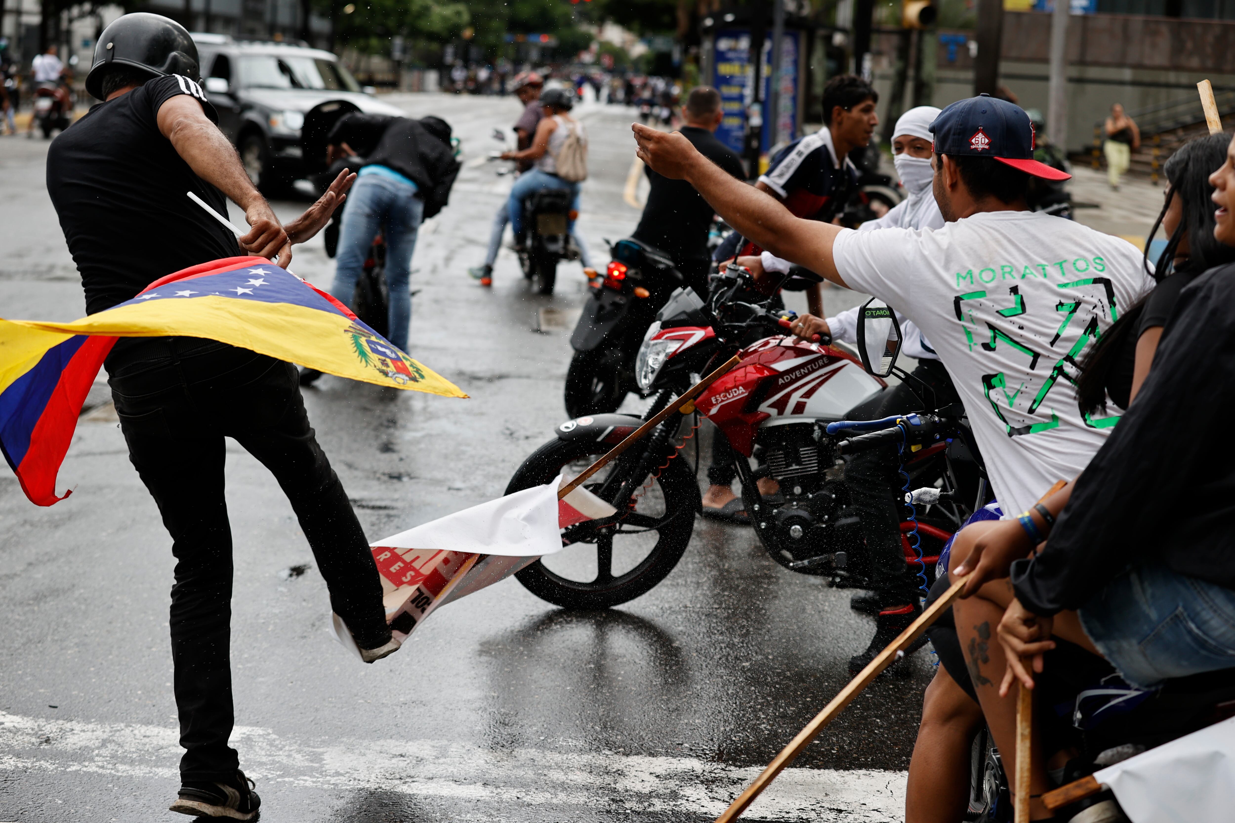Una persona patea un cartel con la imagen del presidente de Venezuela, Nicolás Maduro, durante una protesta por los resultados de las elecciones presidenciales este lunes, en Caracas (Venezuela).  EFE/ Henry Chirinos