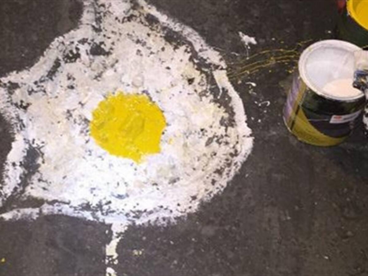 Grupo de jóvenes pinta huevos fritos en los huecos de Bogotá