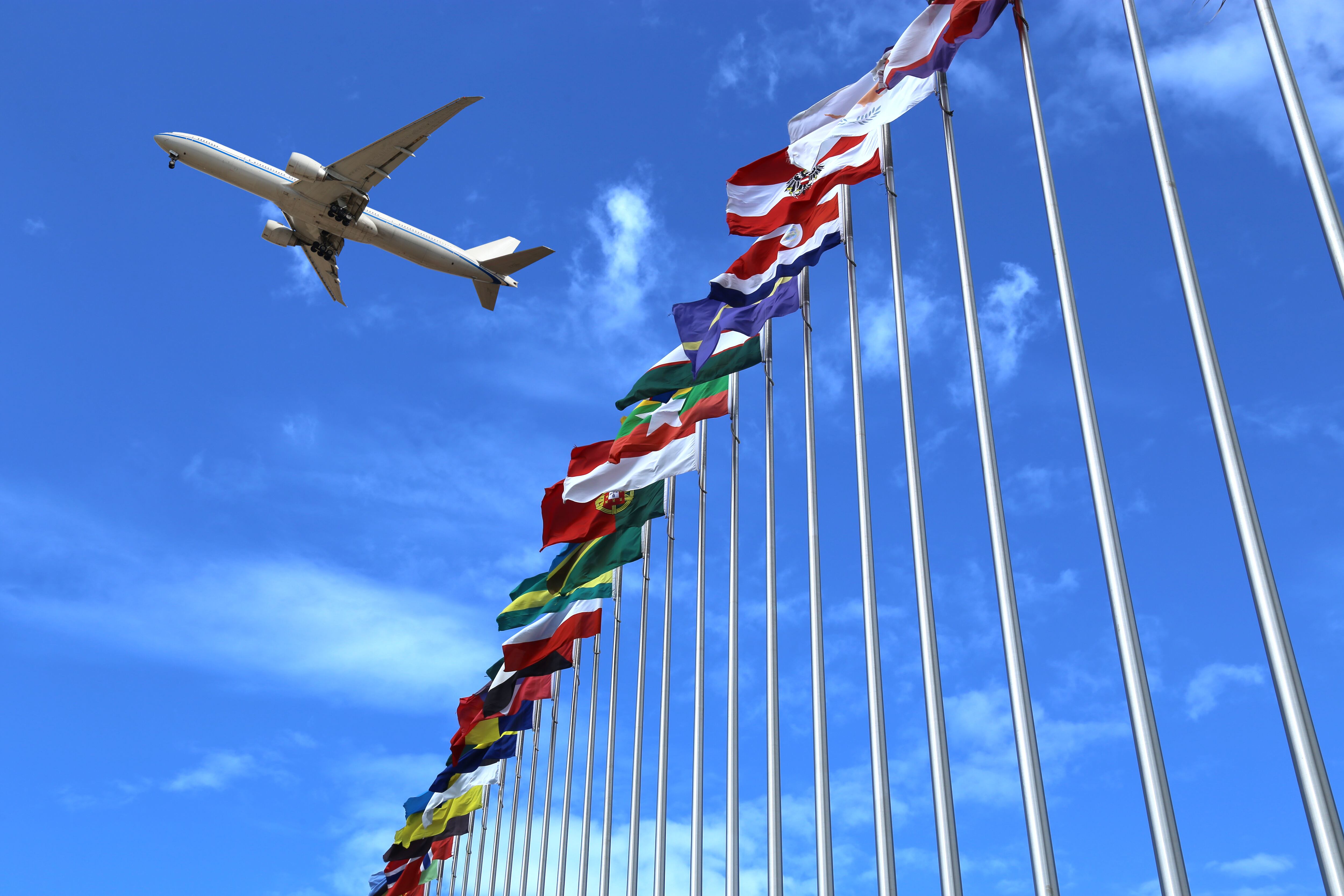 Avión volando sobre banderas de diferentes países / Foto: GettyImages