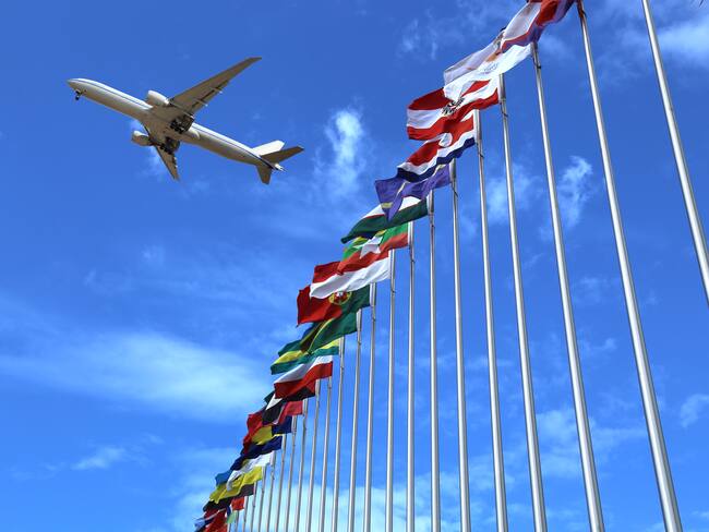 Avión volando sobre banderas de diferentes países / Foto: GettyImages