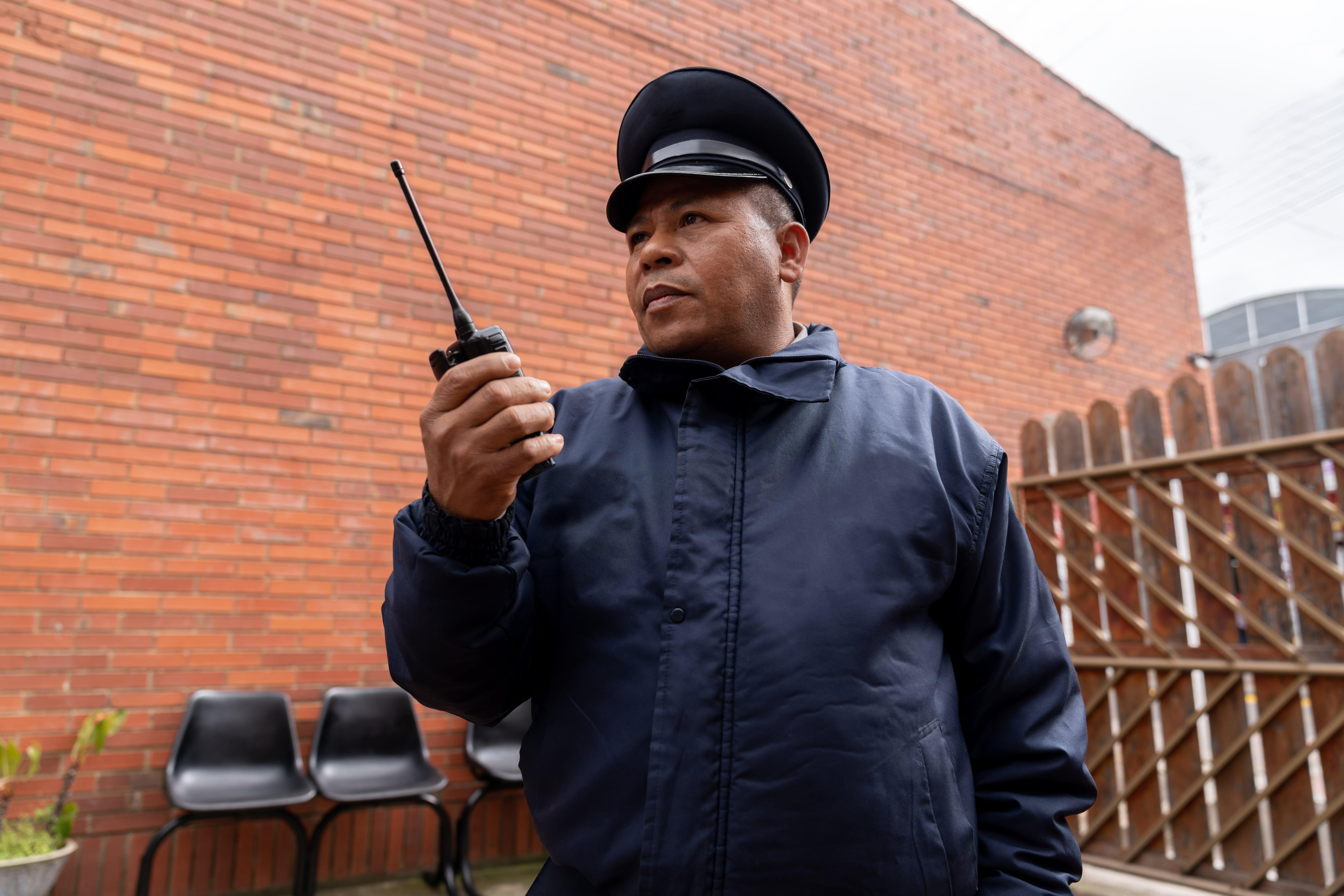 Hombre vigilante de seguridad con su radio en la mano (Getty Images)